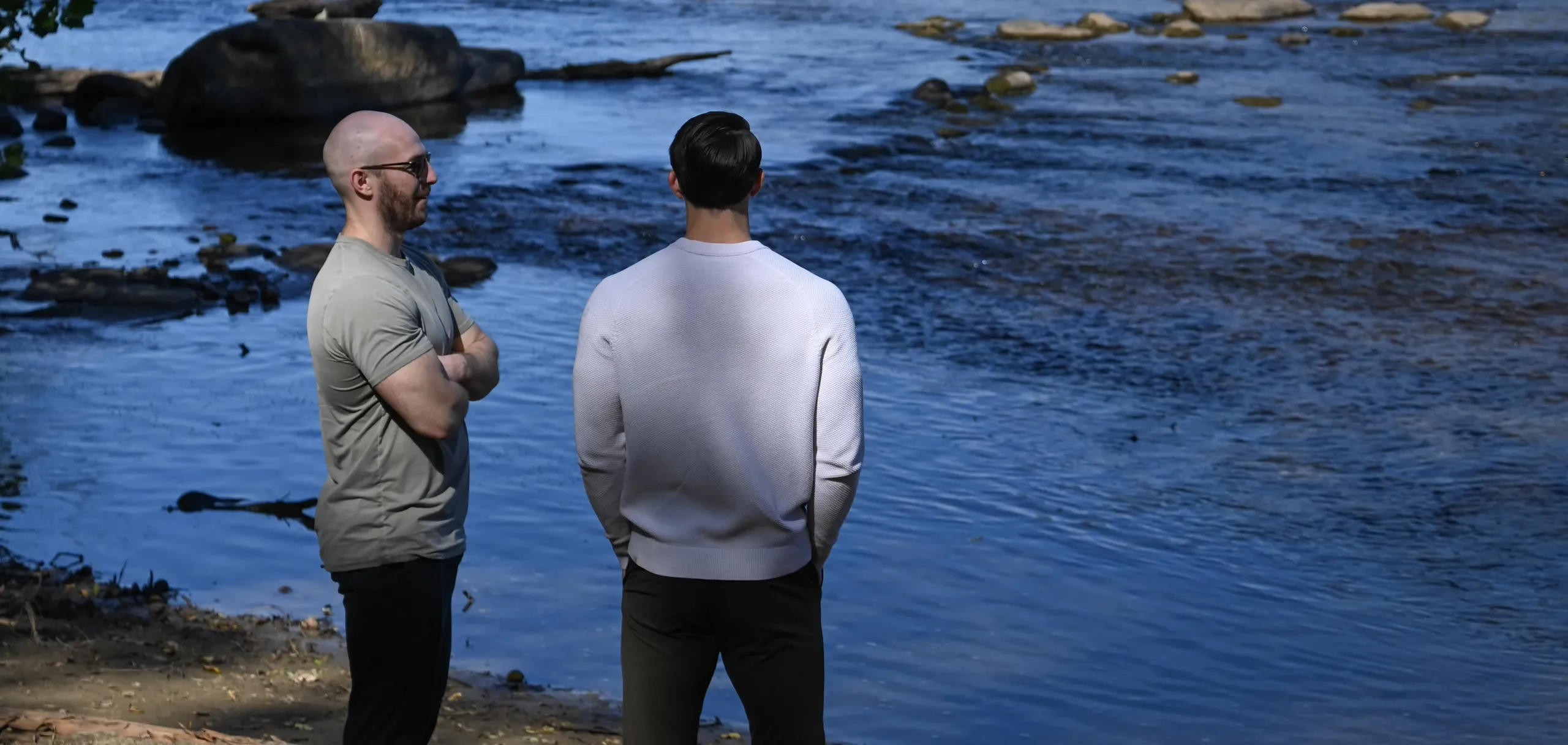 Two men standing together at the edge of the James River
