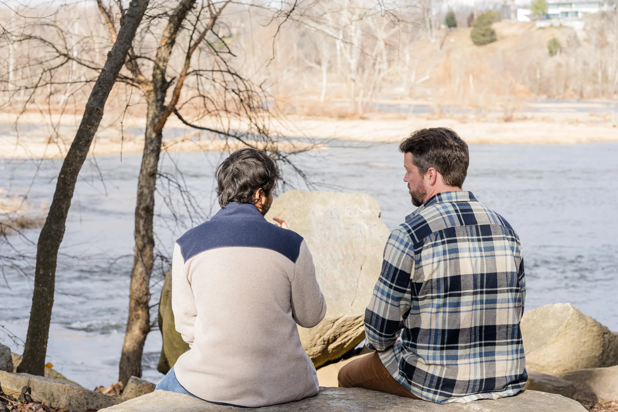 Two men sitting on the rocks beside the James River at Pony Pasture