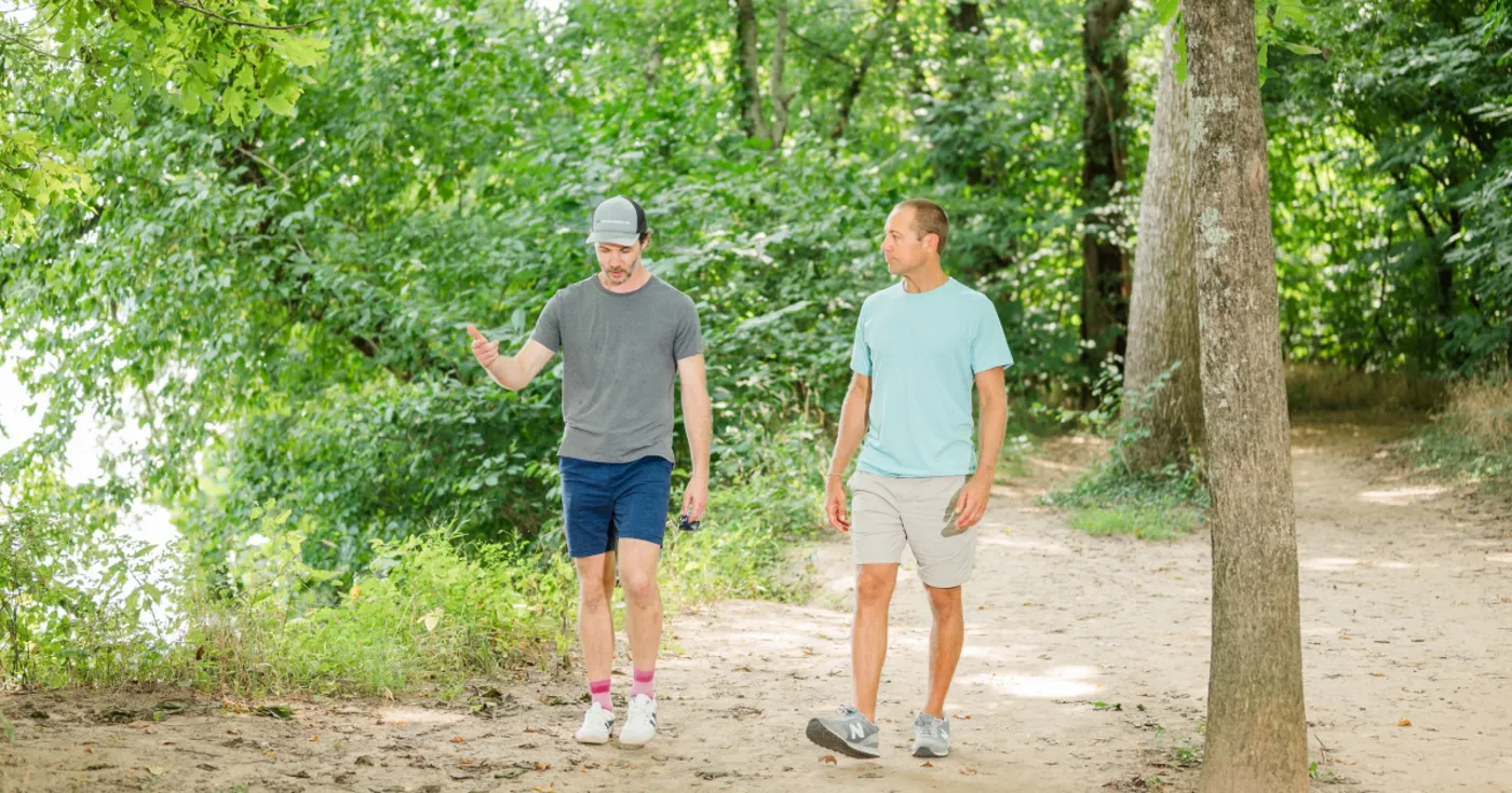 Two men talking while walking a trail beside the James River